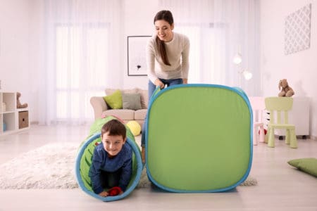 Young boy playing inside a crawl tunnel