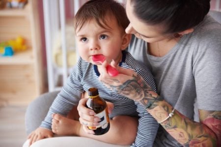 Mother giving her baby medicine