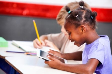 Little girl playing with a tablet