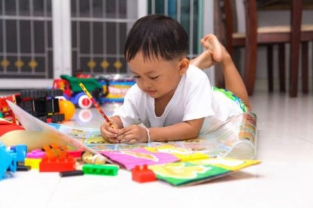 Toddler boy drawing on the floor