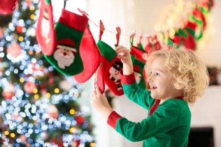 Little boy in a green costume opening presents.