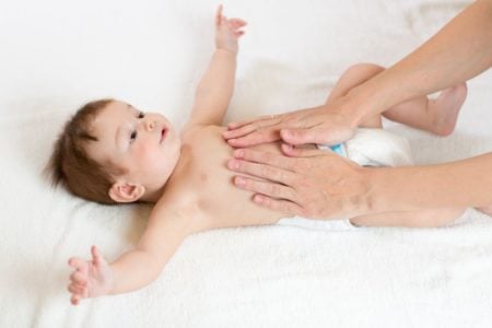 Baby given a belly massage