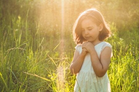 Cute little girl making a wish in the park