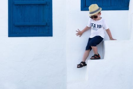 A little boy playing on the street of Mykonos in Greece