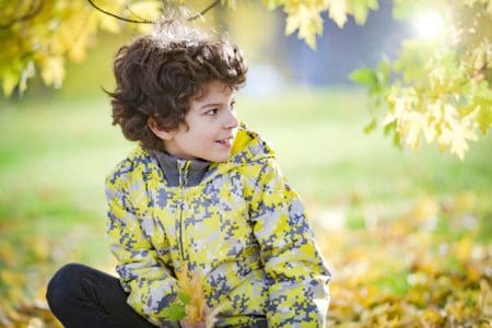 Cute little boy playing in the autumn park