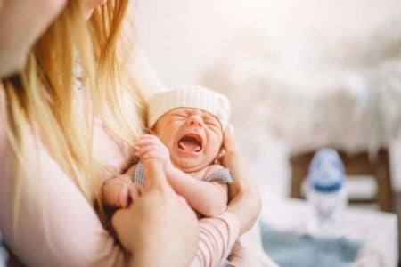 Newborn crying in mother's arms