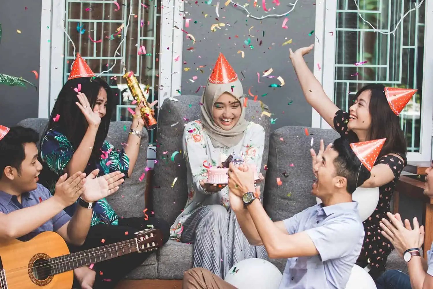 Birthday celebrant holding cake having fun with her friends