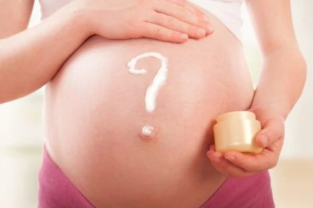 Woman performing belly mapping to decide if baby is head down