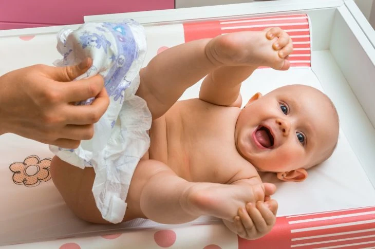 Baby having his diaper changed on a changing pad