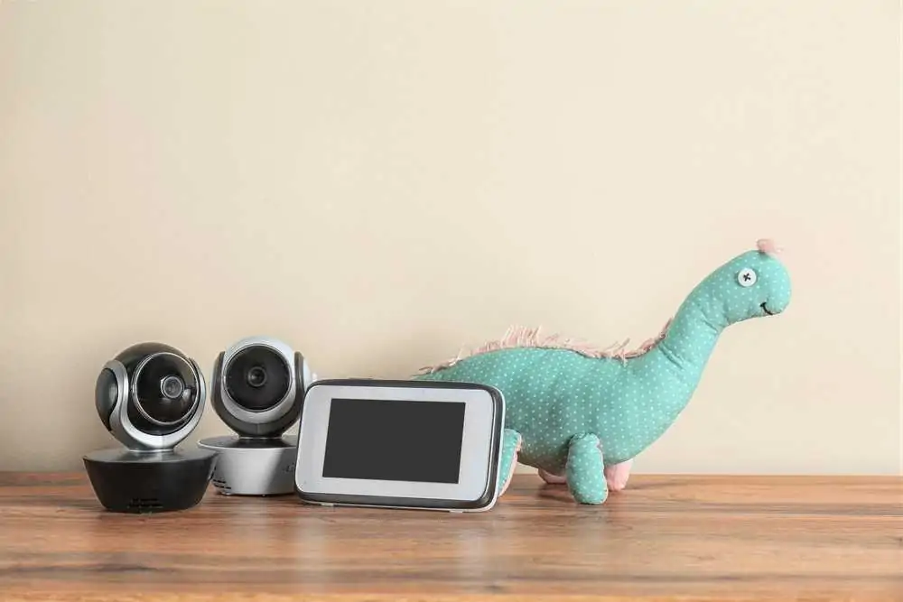 Dual screen baby monitors and toy on wooden table