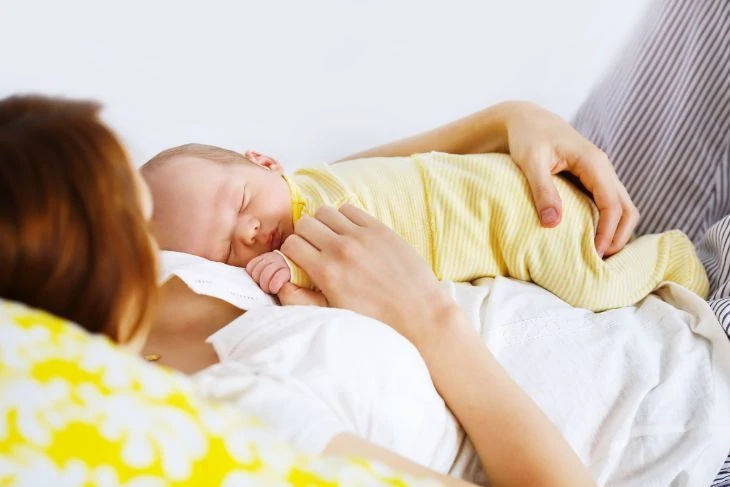 Newborn baby sleeping with mother