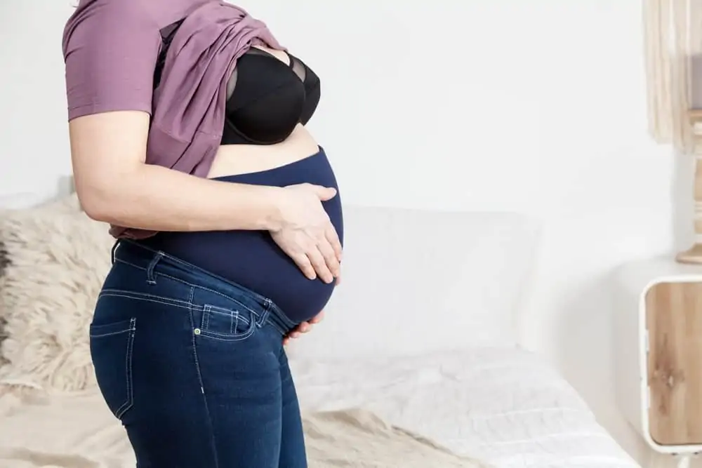 A pregnant woman wearing elastic pant extender