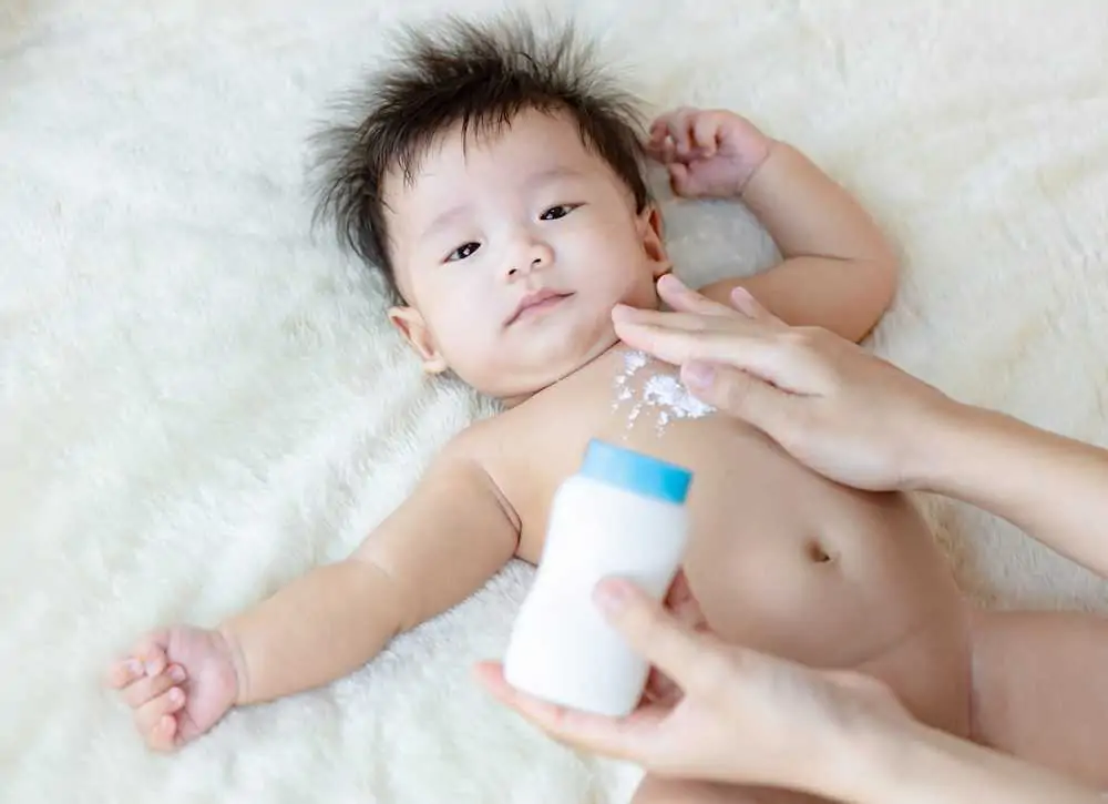 Mother applying talcum powder on her baby