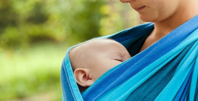 Baby is sleeping in sling, close up face